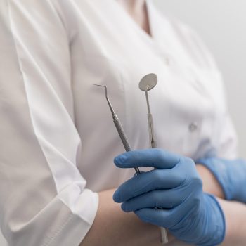 female-orthodontist-with-latex-gloves-handling-dental-equipment